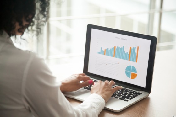 woman on laptop with chart showing data trends